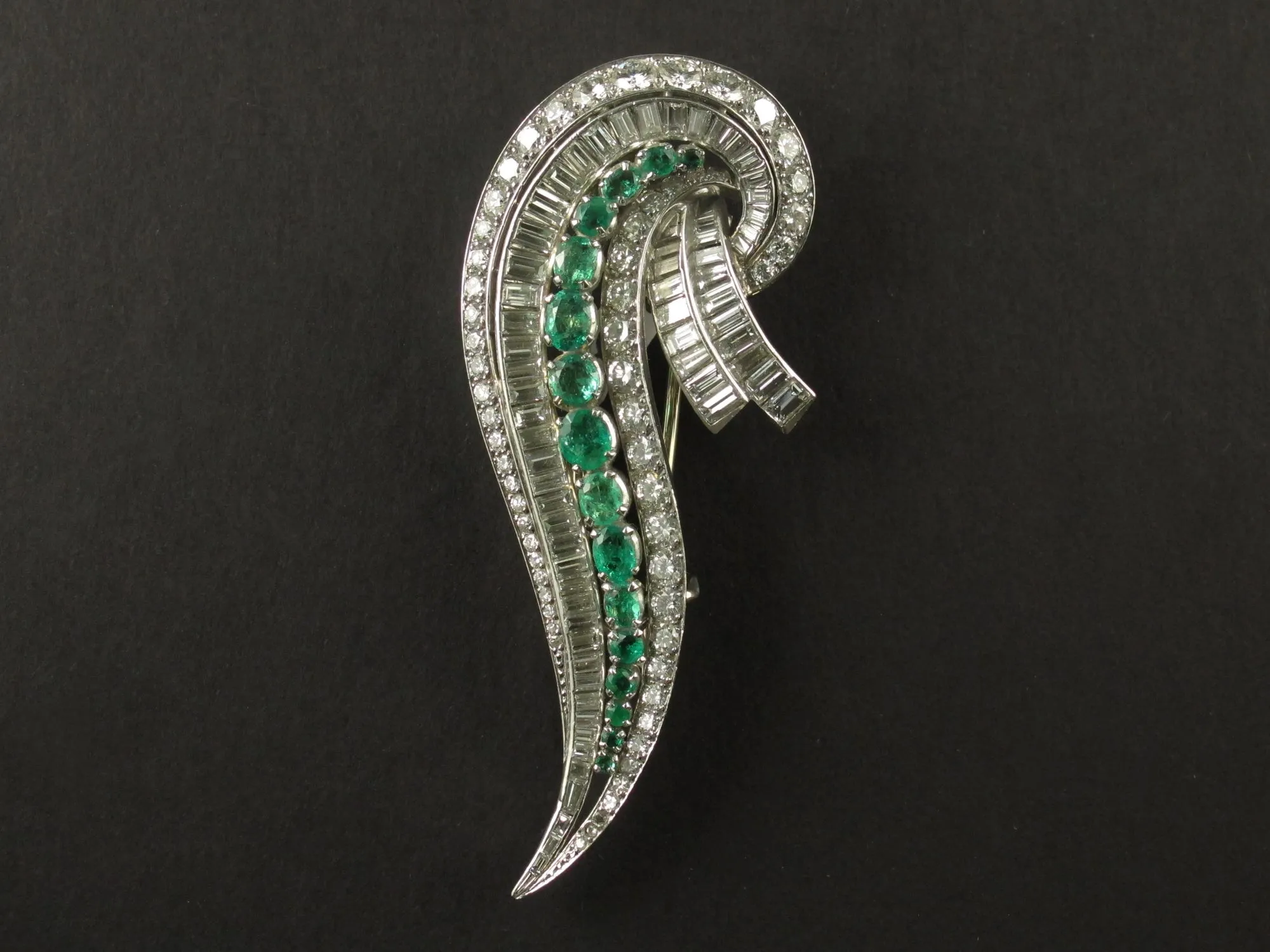 An Art Déco platinum, diamond and emerald brooch. 1935 circa